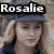 Pixelated image of a person with light brown hair wearing a dark blue cap and dark clothing, with a black banner displaying white text above the head.