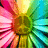 A vibrant, pixelated flower with radiating petals in pink, yellow, green, and cyan hues, centered on a gray background.