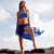 Pixelated static image of a person in blue swimwear standing on one leg against a light sky background.