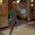 Animated sequence showing a woman in a blue dress walking through a hallway, then sitting and lying down on a dark background.
