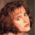 Pixelated close-up of a person with curly brown hair and light skin, facing right with a neutral expression.