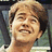 Pixelated close-up of a smiling person with light brown hair against a blurred background.