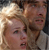 Pixelated static image of two human faces in close proximity with visible facial features and partial clothing, rendered at low resolution on a gray background.