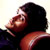 Pixelated static image of a person with dark hair and reddish skin tones in profile view, wearing a red garment against a light background.