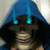 A hooded figure with glowing blue eyes and a blue hooded cloak, smiling with visible teeth against a light background.