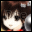 Pixelated anime-style character with brown hair and red clothing, displaying sequential text changes over a blurred background.