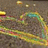 Pixelated static image with abstract multicolored shapes on a brownish-gray background, featuring scattered yellow, green, blue, and pink elements.