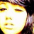 Pixelated close-up of a smiling face with closed eyes, yellow-toned skin, and dark hair against a bright background.