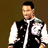 Pixelated image of a person wearing a black vest over a white long-sleeve shirt with a zipper, standing against a brown background.
