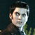 Pixelated close-up of a person with dark hair wearing a dark jacket over a light shirt against a dark background.
