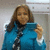 A person in a blue jacket holds a device, with background elements visible across four