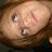 Pixelated image of a person with brown hair and a red mark on their face, accompanied by green pixelated text on a white background.