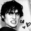 Black-and-white image of a person with tousled dark hair, mouth open in a grimace, three hand-drawn hearts floating to the right.