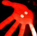 A static red hand icon with two white circular eyes on the palm, set against a dark background.
