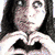 A person with long dark hair forms a heart shape with hands against a light background, while the right side shows a color-inverted version of their face on red.