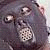 Pixelated static image of a dark-colored animal face with light eyes and nose, likely a cat or similar feline creature, rendered in low-resolution grayscale tones on a transparent background.