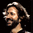 Pixelated buddy icon split into two vertical sections: left side shows a person with long hair and beard against black background, right side displays green text on dark green background.