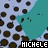 A static image shows a teal cartoon cat with closed eyes and small black pupils on a light blue background covered in brown polka dots, with the text "MICHELE" displayed below.