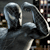 Two stylized metallic figures with curved silver outlines and dark gray interiors stand side-by-side against a pixelated background.