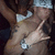 A person in a white cap and dark clothing points with their right hand while wearing a silver wristwatch, captured across four