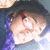 A person with purple hair and glasses appears in a of four , showing subtle changes across frames