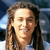A person with long brown hair and a light blue shirt smiles in four pixelated views showing slight variations in brightness and cropping.