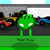 Green pixelated frog stands on green ground with blurred background of colorful vehicles and gray structures.
