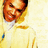 Pixelated close-up of a person with light brown hair wearing a white shirt and yellow tie against a pale background.