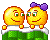 Animated pixel art of two yellow circular characters with purple bows on a green checkered platform, transitioning from standing to lying down and back up.