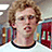 Pixelated image of a person with curly light brown hair wearing glasses and a white shirt, next to red text reading 'gosh!!!!!!' on a light blue background.