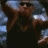A man in a black tank top and dark sunglasses performs a sequence of arm movements against a blurred blue background.
