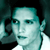 Pixelated static image of a person's face with teal and white color scheme, dark background, and visible dithering artifacts.
