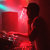 A pixelated static image with dominant red tones and a small cyan highlight on the left edge, showing indistinct shapes and no clear subjects or text.