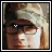 Animated contact sheet of 25 frames showing a person with light brown hair wearing glasses and a striped headband, with subtle eye movements across sampled frames.