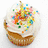 A cupcake with white frosting and colorful sprinkles appears in two , one static and one with overlaid text