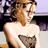 Static 48x48 pixel icon showing a partial view of a person with light brown hair and bare shoulders, wearing dark clothing or bikini bottom, against a blurred background with purple and black tones.