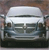 Pixelated static image of a white vehicle with dark accents and visible wheels against a brownish background.