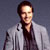 Static pixelated image of a person in a light-colored jacket against a dark background with visible dithering and low-resolution rendering artifacts.