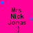 A static image with a bright pink background, blue stars scattered around, and repeated text "Mrs. Nick Jonas :)" in black pixelated font.