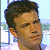 Pixelated close-up of a person's head and neck with short dark hair, light skin, and closed eyes against a light blue background.
