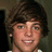 A pixelated image of a person with brown hair and a white shirt on a blue background with pink text and heart symbols.
