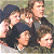 A 50x50 pixel animated contact sheet showing two frames of a group scene with four people on the left and green text reading "Original Icons .com" on the right against a dark background.