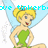 Pixelated image of a female character with blonde hair in a bun, green dress, and light blue wings, standing with hands on hips.