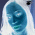 Pixelated blue and white abstract shape with a dark circular element on the right side, set against a gradient background.