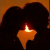 A pixelated heart-shaped icon with a candle inside, set against an orange-brown gradient background.