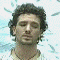 20 pixelated head-and-shoulders portraits showing a man with curly dark hair against a light blue patterned background, transitioning from neutral to smiling expressions