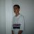 Pixelated static image of a person in light-colored clothing with dark hair against a plain background.