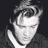 Static grayscale pixel art of a person's face with closed eyes, styled hair, and visible facial features against a dark background.