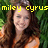 Pixelated image of a person with long brown hair wearing an orange top, set against a green background with yellow text reading 'miley cyrus' above the head.