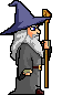 Pixel art wizard with purple hat, gray robe, white beard, blue eyes, brown belt, and wooden staff with golden top, shown in four sequential poses.